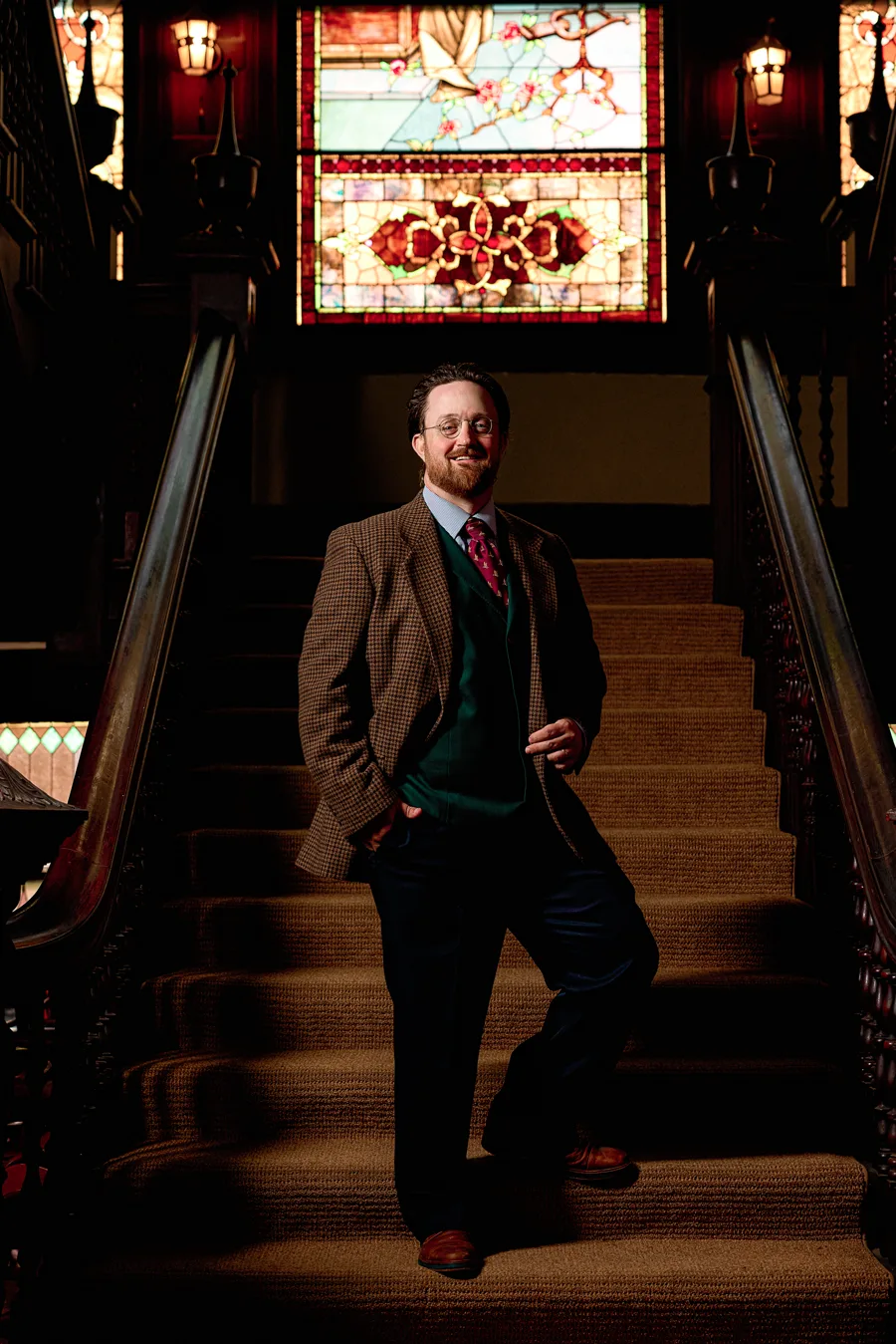 Kris Geiger in tweed on a Victorian staircase